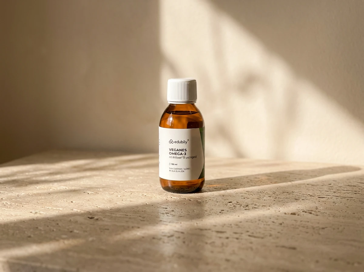 Braune Glasflasche edubily Veganes Omega-3 Öl mit weißem Deckel auf einer Natursteinfläche