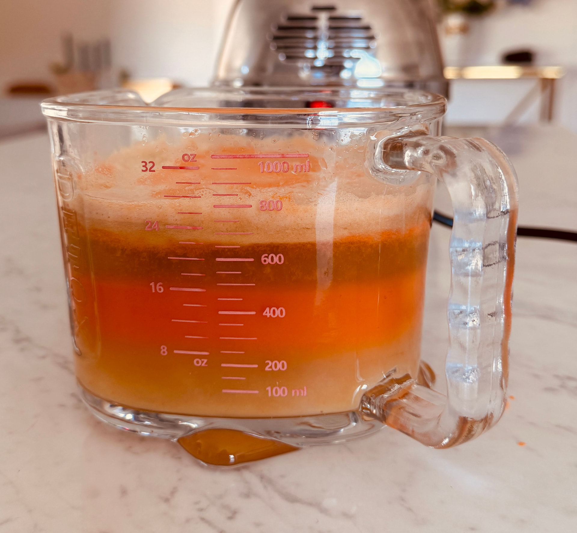 Messbecher mit rund 800 ml frisch gepresstem Saft vor dem Angel Juicer 7500